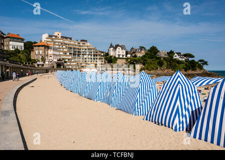 Blue and white striped sunshades on the beach, Plage de L'Ecluse, Dinard, Brittany, France Stock Photo