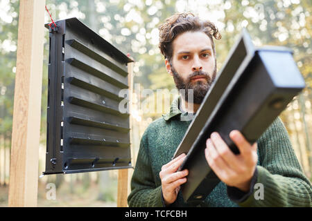 Forester controls a bark beetle trap in the forest as pest control Stock Photo