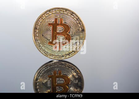 Golden Bitcoin on glass table. Abstract photo of virtual cryptocurrency. Stock Photo
