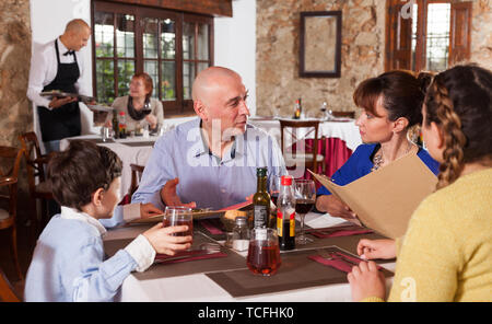Happy family having dinner and nice talking at restaurant Stock Photo