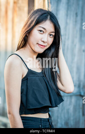 A beautiful Thai girl poses at the famous tourist landmark Pae Gate, Chiang Mai, Thailand. Stock Photo