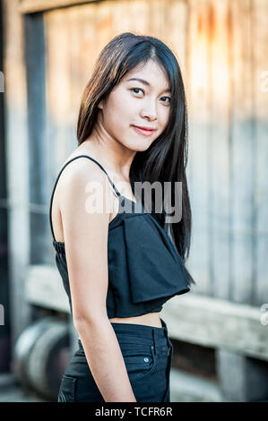 A beautiful Thai girl poses at the famous tourist landmark Pae Gate, Chiang Mai, Thailand. Stock Photo