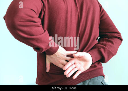 A man holding his back an attack of renal colic. Urolithiasis. The concept of health Stock Photo