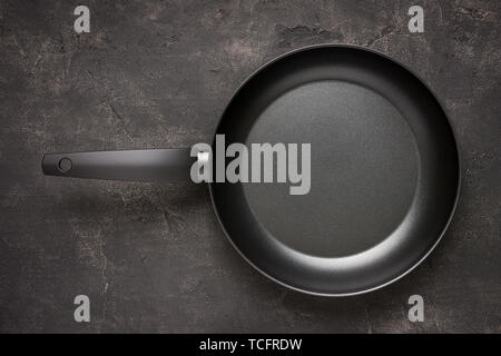 Empty Frying Pan Black on Dark Stone Surface. Culinary Background. Stock Photo