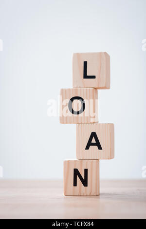 stacked wooden cubes with black loan inscription on wooden surface isolated on grey Stock Photo