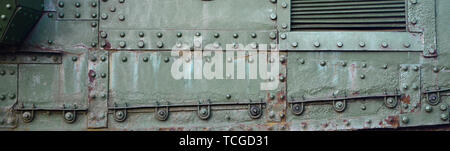 Abstract green industrial metal textured background with rivets and bolts. Old painted metal backdrop, detail of military tank surface corrosion, meta Stock Photo