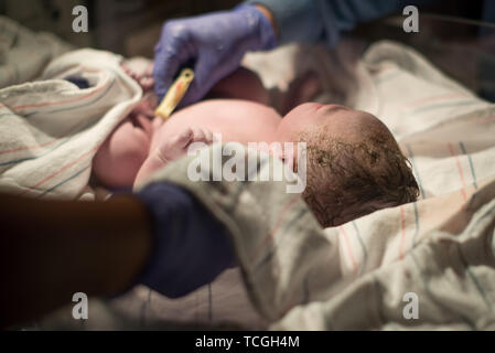 Multi-ethnic newborn baby immediately after being born / childbirth being cared for by nurses and health professionals Stock Photo