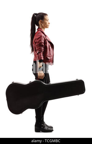 Full length profile shot of a female musician standing and holding a guitar in a case isolated on white background Stock Photo