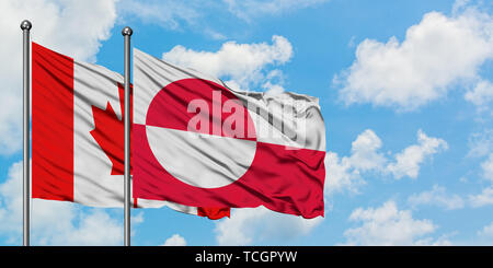 Greenland and Canada flag waving in the wind against white cloudy blue ...