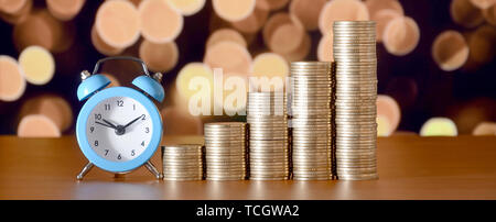 Time for savings money concept, banking and business idea. Alarm clock and Money coin stacks in grow graph. Finance sustainable development and econom Stock Photo