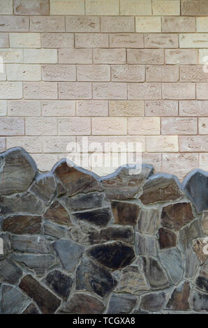 Rustic old beige white brick wall background and worn foundation with shabby brown stones Stock Photo