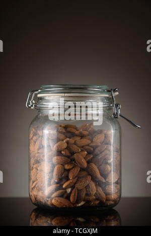 Raw almonds in glass jar with lid and metal clasp Stock Photo