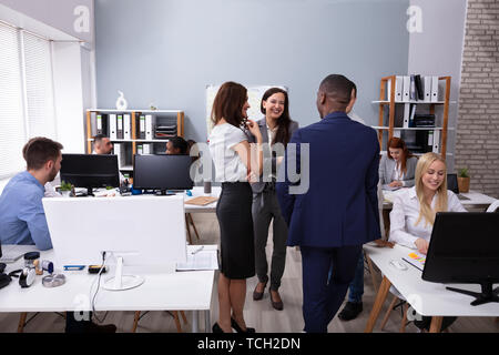 Group Of Businesspeople Discussing Together With His Colleague Working In The Office Stock Photo