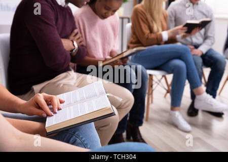 Close-up Of Woman Hand Holding Open Bible Stock Photo