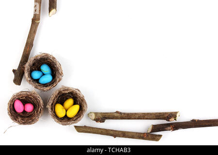 Colorful easter eggs in nests isolated on white Stock Photo