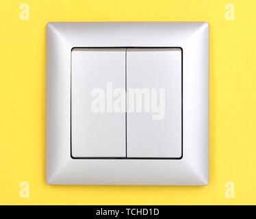 Modern light switch on yellow background Stock Photo