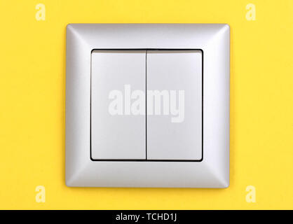 Modern light switch on yellow background Stock Photo