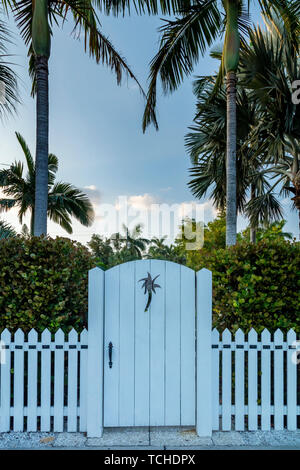 White picket fence and wood gate with palm tree cutout, Naples, Florida, USA Stock Photo