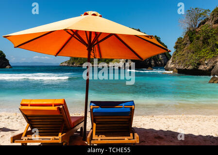 Pair of sun loungers and a beach umbrella on a deserted beach. Perfect vacation concept Stock Photo