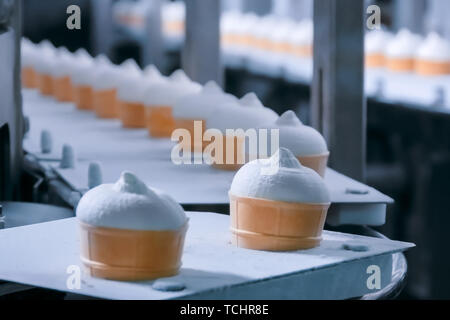 Automated technology concept - conveyor belt with icecream cones at food factory Stock Photo