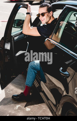 Young man phone poses with his car. Stock Photo | Adobe Stock