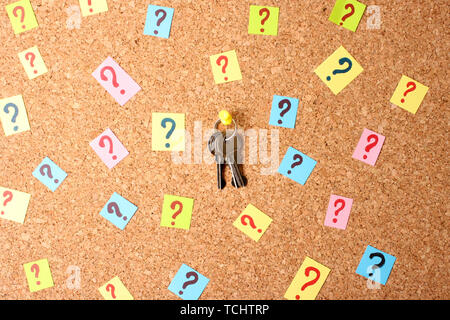 Keys with many question marks on cork board Stock Photo