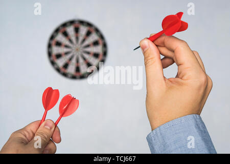 Businessman holding a dart aiming at the target - business targeting, aiming, focus concept. man in blue shirt playing Darts. hit the target. Success  Stock Photo