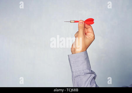 Businessman holding a dart aiming at the target - business targeting, aiming, focus concept. man in blue shirt playing Darts. hit the target. Success  Stock Photo