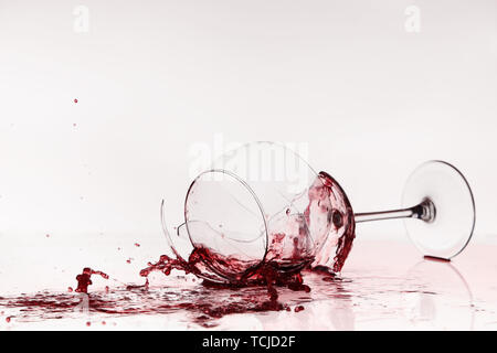 Broken wineglass on the table. Poured red wine, like blood. Stock Photo
