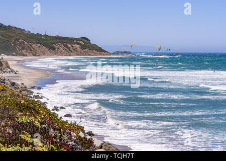 The Pacific Ocean coastline close to Santa Cruz, California; unidentified people windsurfing on a sunny day at Waddell Beach Stock Photo