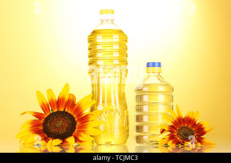 sunflower oil and sunflowers on yellow background Stock Photo