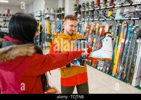 Couple choosing ski or snowboarding boots Stock Photo