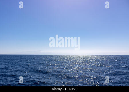 Seascape with sea horizon and almost clear deep blue sky Stock Photo