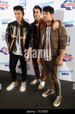 Members of the band the Jonas Brothers (left to right) Nick Jonas, Kevin Jonas and Joe Jonas on the red carpet of the the media run during Capital's Summertime Ball. The world's biggest stars perform live for 80,000 Capital listeners at Wembley Stadium at the UK's biggest summer party. Stock Photo