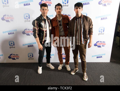 Members of the band the Jonas Brothers (left to right) Nick Jonas, Kevin Jonas and Joe Jonas on the red carpet of the the media run during Capital's Summertime Ball. The world's biggest stars perform live for 80,000 Capital listeners at Wembley Stadium at the UK's biggest summer party. Stock Photo