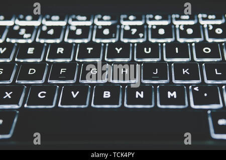 Illuminated Keyboard. White light on the laptop keyboard. Stock Photo
