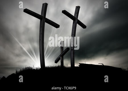 Three silhouettes of Christian crosses above a hill on a cloudy sky. Religious symbol of good friday Stock Photo