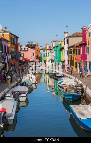 Moored boats on canal lined with colourful houses, shops and tourists, Burano Island, Venetian Lagoon, Venice, Veneto, Italy Stock Photo