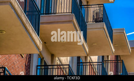 Panorama Close up of building exterior with brick small balconies and red brick wall Stock Photo