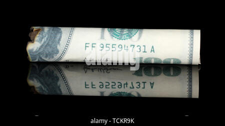 Cigar of the 100 dollar bill isolated on black Stock Photo