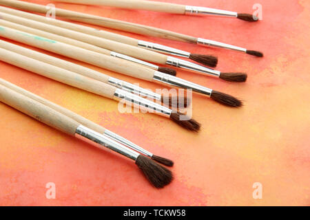 brushes on bright abstract gouache painted background Stock Photo