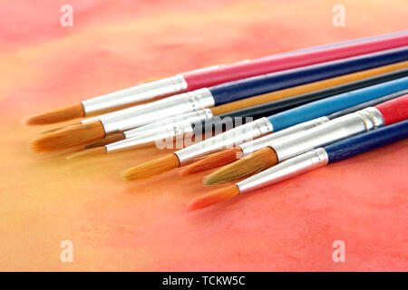 brushes on bright abstract gouache painted background Stock Photo