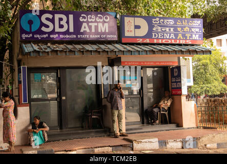 BANGALORE INDIA June 3, 2019 :People sitting infront of the SBI ATM and DENA bank ATM's at bangalore railway station. Stock Photo