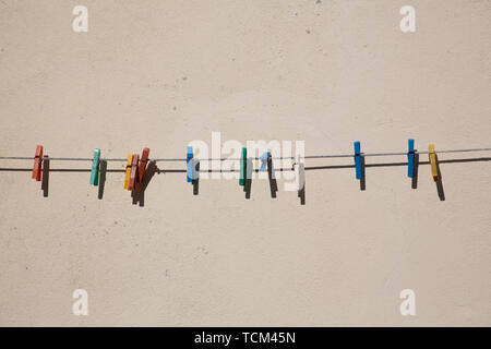 Simple array of colourful clothes pegs or clothes pins on washing line Stock Photo