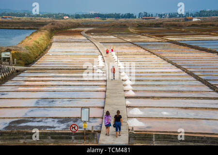 People walking between the salt beds where salt production through solar evaporation of sea water Figuera da Foz Portugal Stock Photo