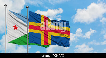 Djibouti and Aland Islands flag waving in the wind against white cloudy blue sky together. Diplomacy concept, international relations. Stock Photo