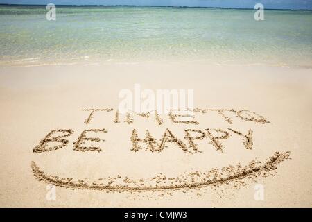 Close-up Of Time To Be Happy Text And Smile Written On Sand At Beach Stock Photo