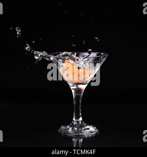 martini cocktail splashing into glass on black background Stock Photo