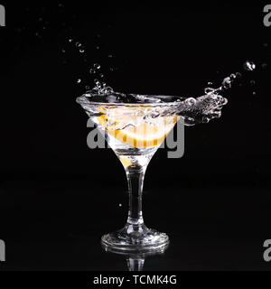 martini cocktail splashing into glass on black background Stock Photo