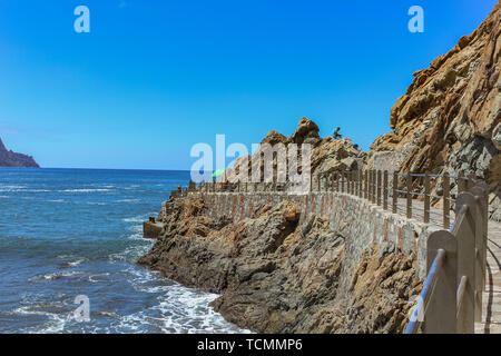 Steep high lava rock cliffs in Los Gigantes, Tenerife. Blue sea horizon, natural sky background. Stock Photo